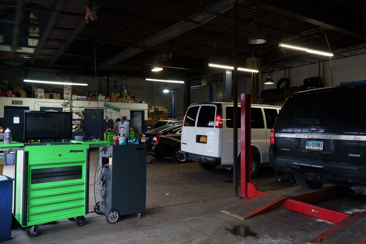 Diagnostic equipment on the shop floor next to vehicles in the bays