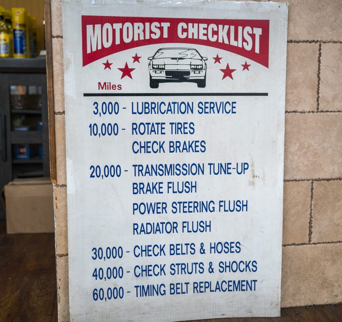 The shop's hand-lettered Motorist Checklist sign listing service intervals by mileage